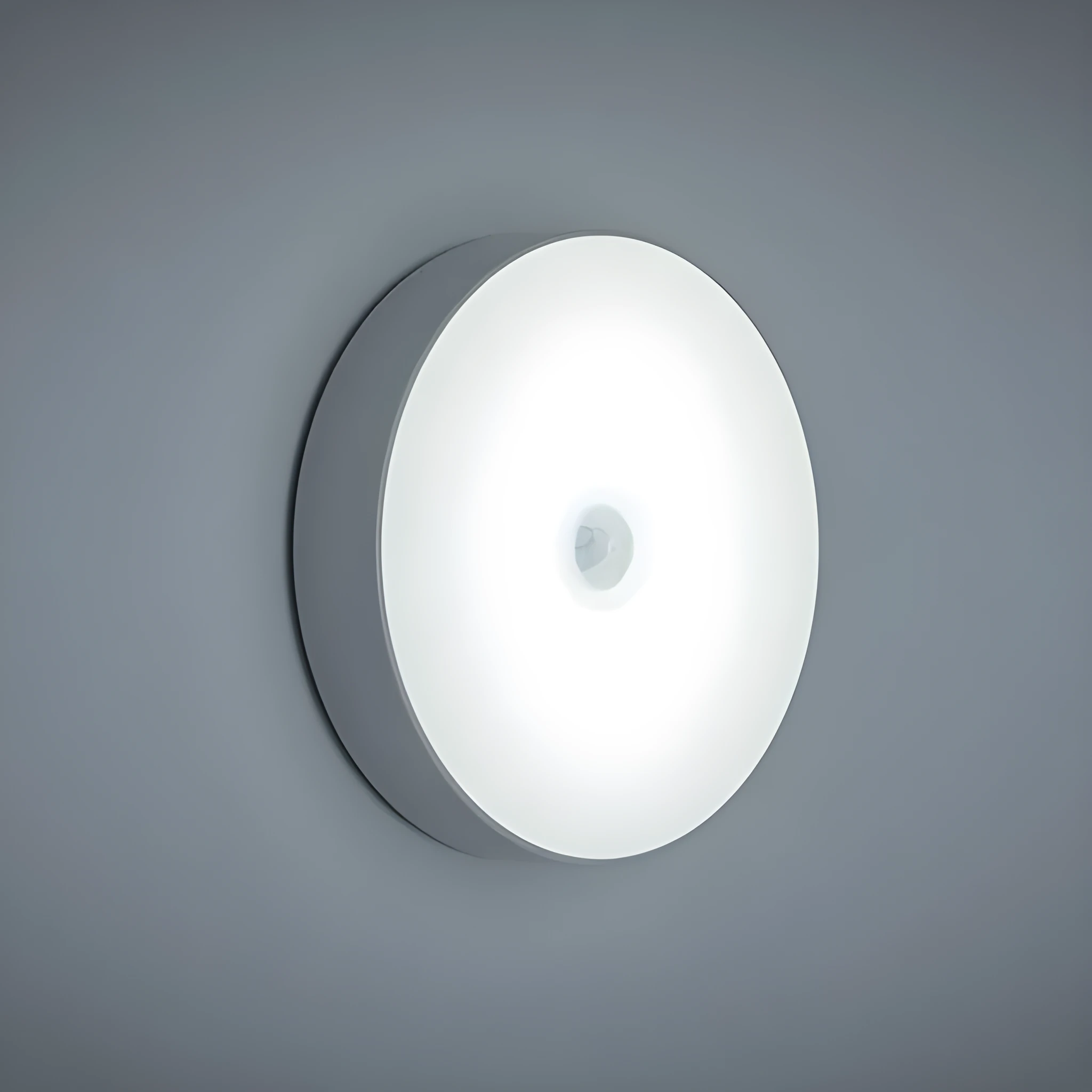 Compact white LED motion sensor night light with USB charging cable on a dark surface.