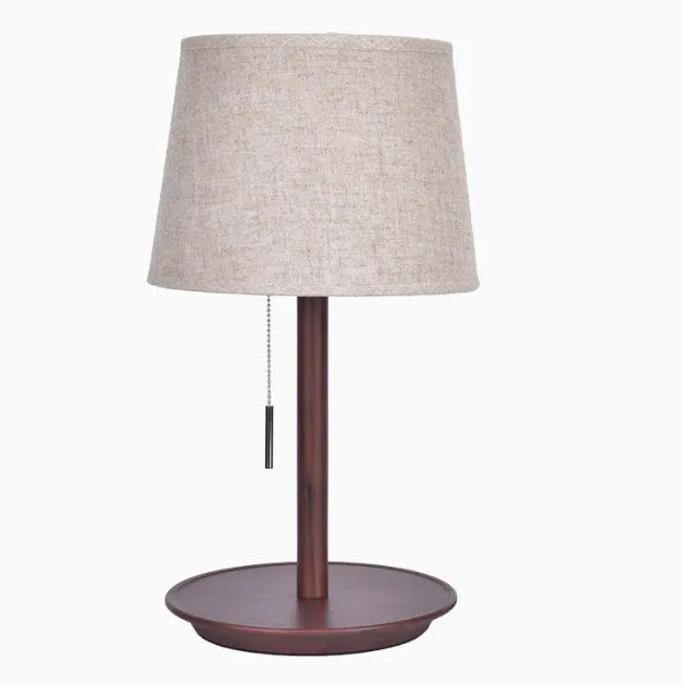 Walnut coloured solid wood bedside lamp with a white fabric lampshade and a cable switch