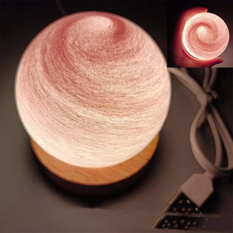 Modern planet-shaped USB night light with dimming on a desk.