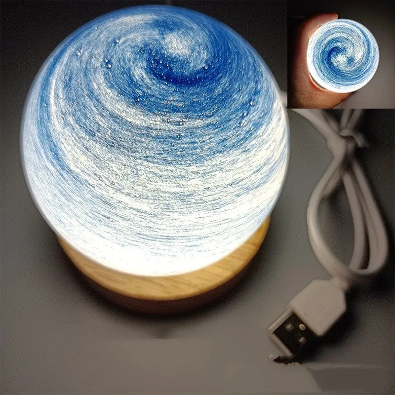 Modern planet-shaped USB night light with dimming on a desk.