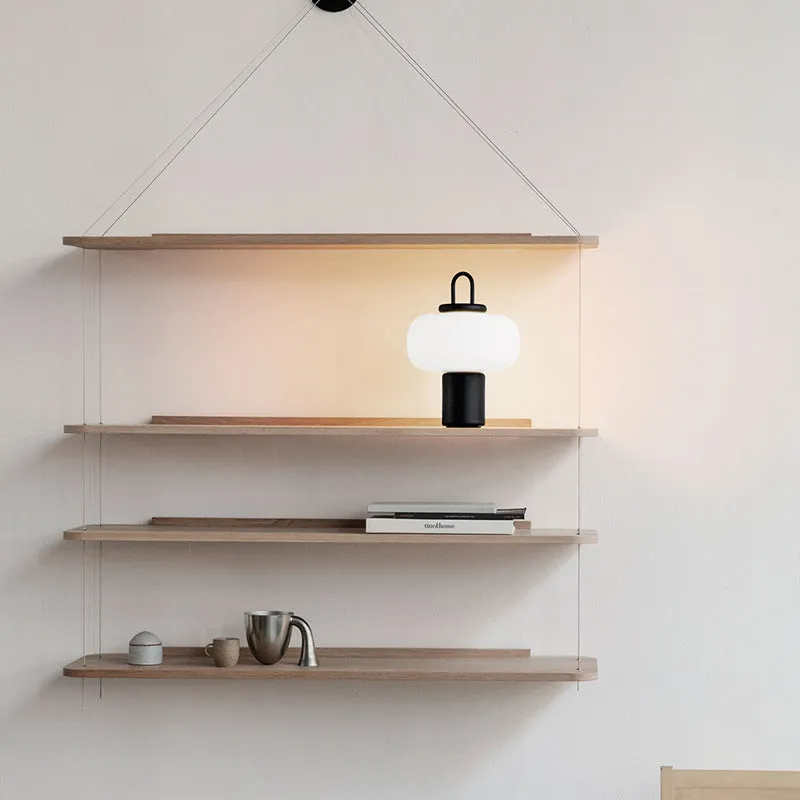Minimalist Japanese designer glass bedside table lamp with warm light for a child's room.