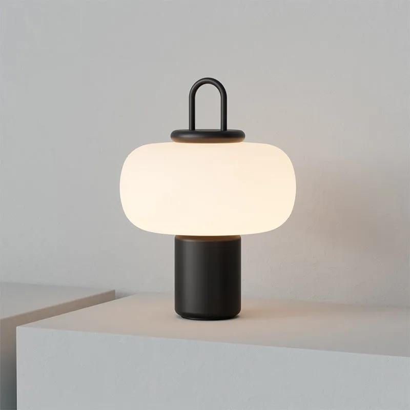 Minimalist Japanese designer glass bedside table lamp with warm light for a child's room.