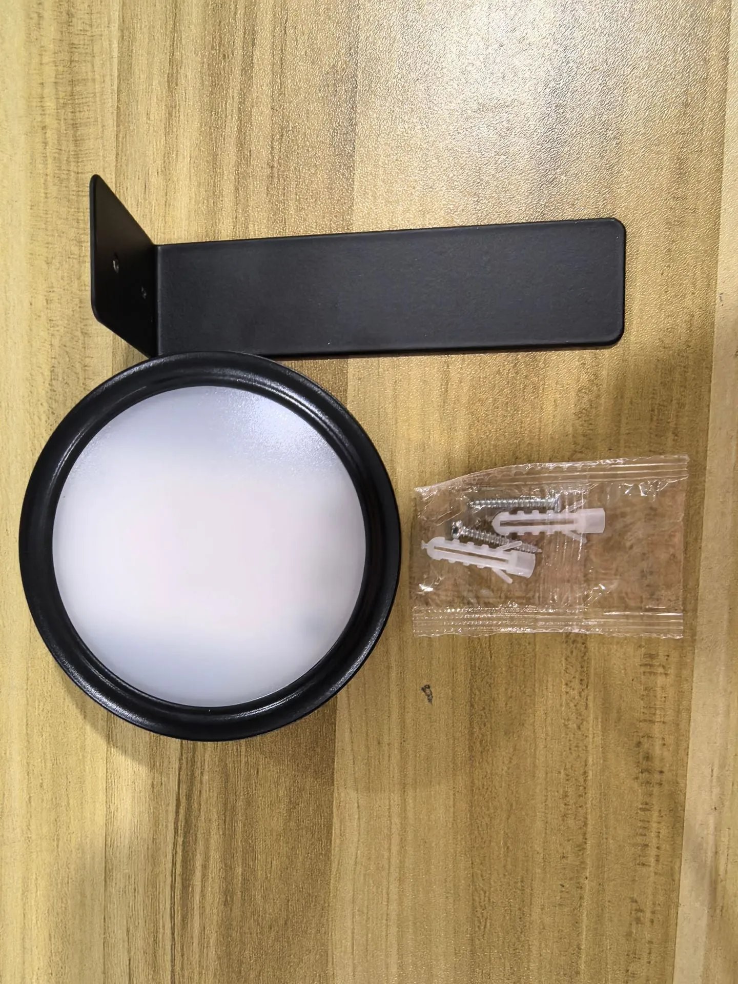 Magnetic LED light bars mounted around a painting, with a remote control on a table nearby.