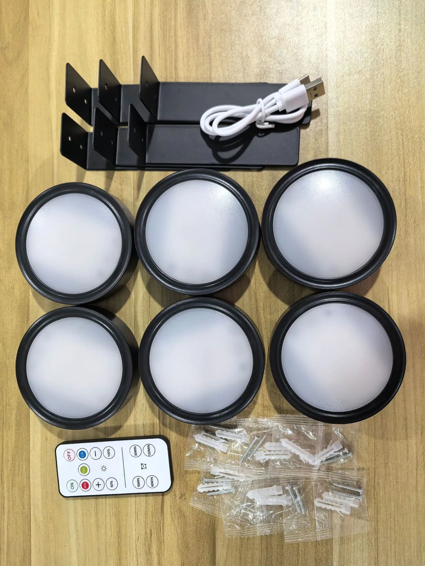 Magnetic LED light bars mounted around a painting, with a remote control on a table nearby.