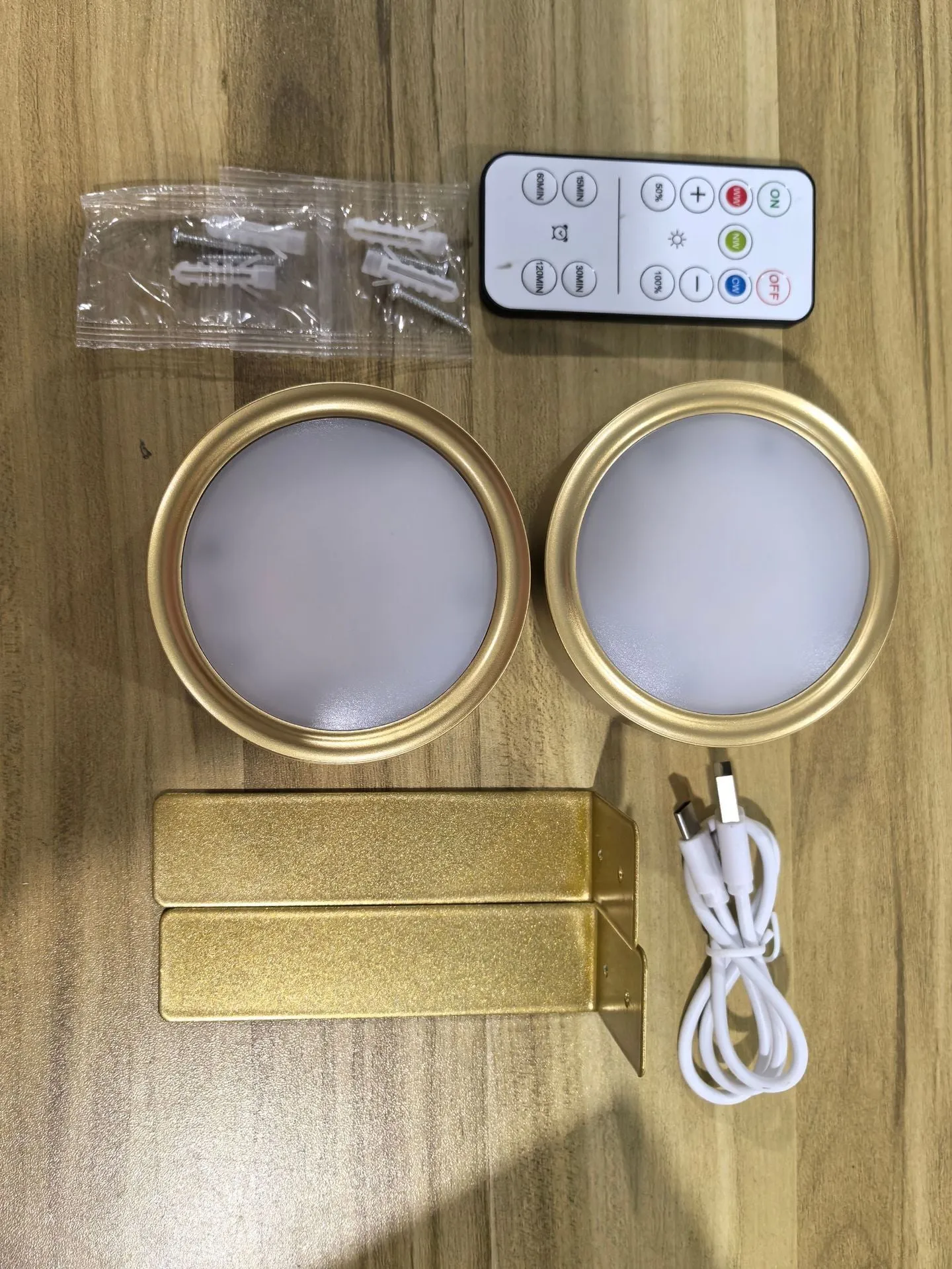 Magnetic LED light bars mounted around a painting, with a remote control on a table nearby.