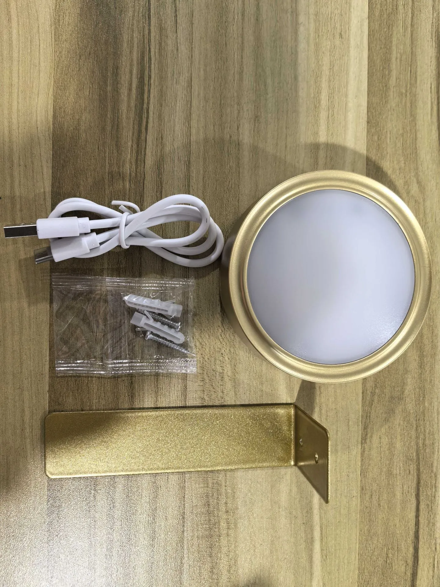 Magnetic LED light bars mounted around a painting, with a remote control on a table nearby.