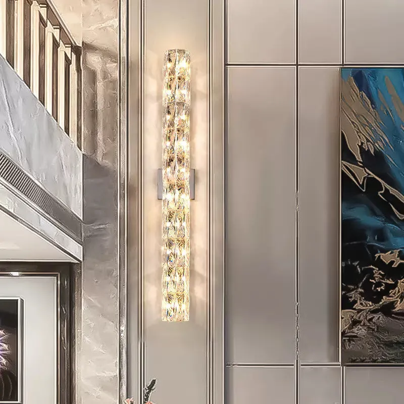A sleek crystal wall lamp with a stainless steel base in chrome finish, mounted on a wall.