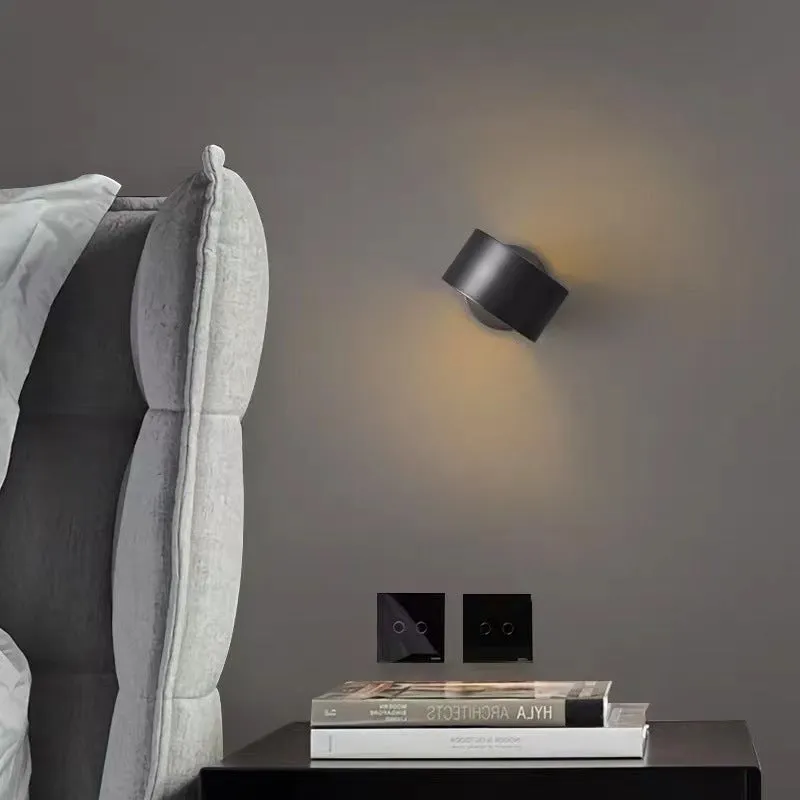 A modern simple style copper wall lamp in a gold finish, mounted on a wall.
