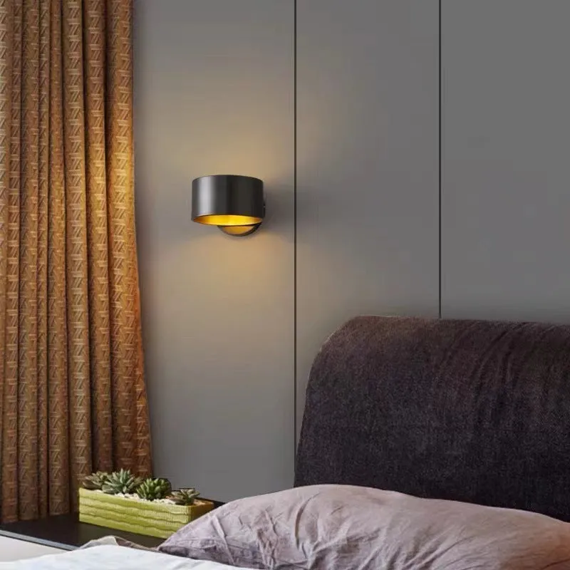 A modern simple style copper wall lamp in a gold finish, mounted on a wall.