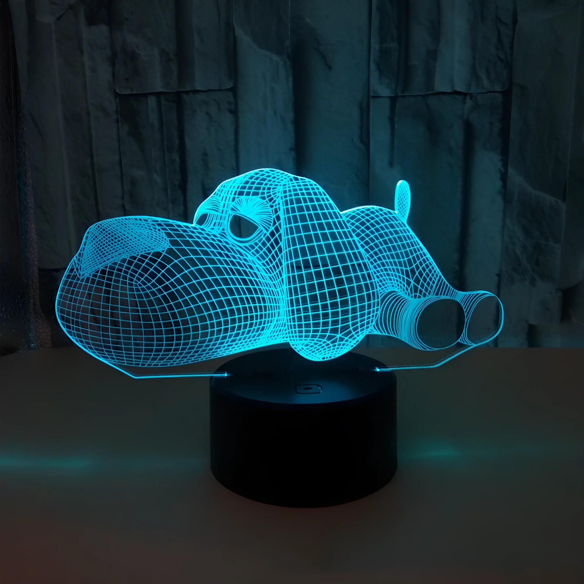 Doggo shaped 3D illusion desktop lamp glowing in multiple colours on a desk.