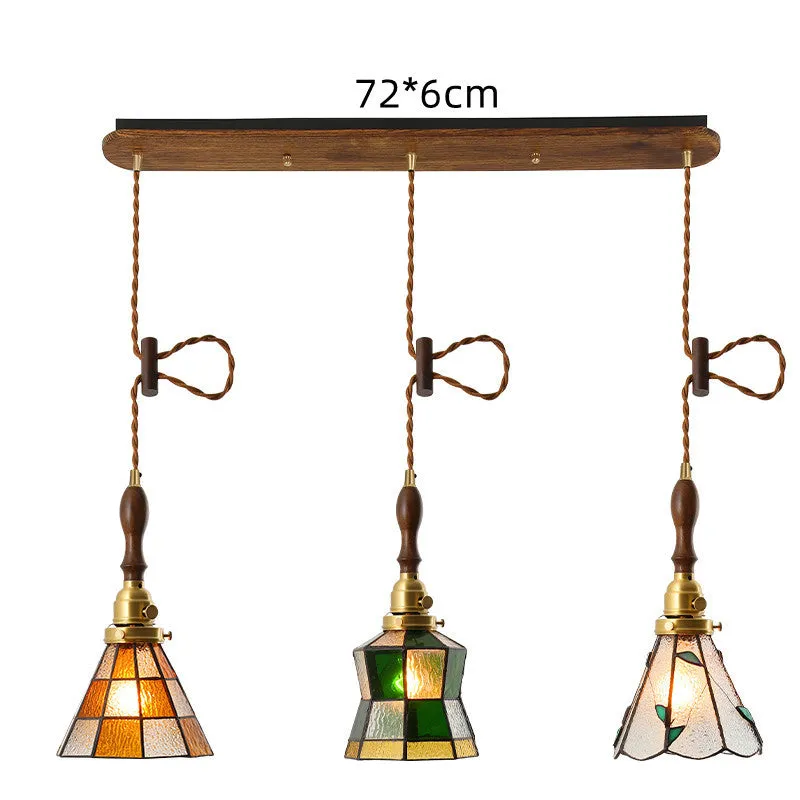 Retro brass and hand-blown glass chandelier with a hemp rope light line hanging from a ceiling.