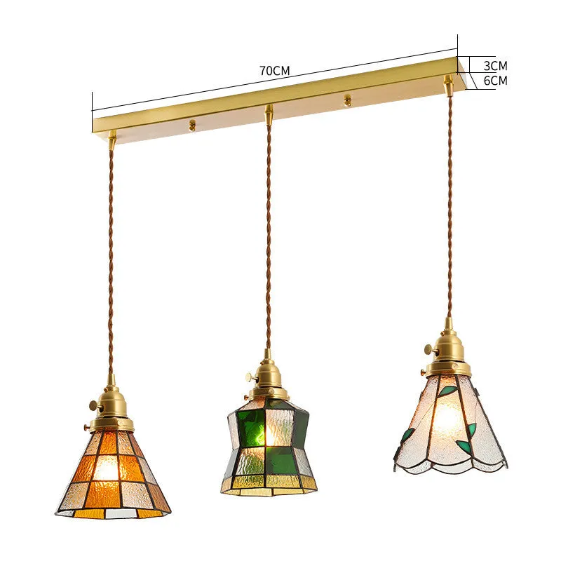 Retro brass and hand-blown glass chandelier with a hemp rope light line hanging from a ceiling.