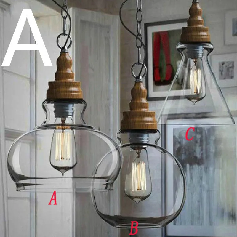 Single head glass pendant light with wood grain finish hanging from ceiling on adjustable cable.