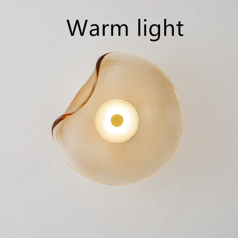 Round glass wall lamp for bedroom bedside in cognac, grey or light colour finishes.