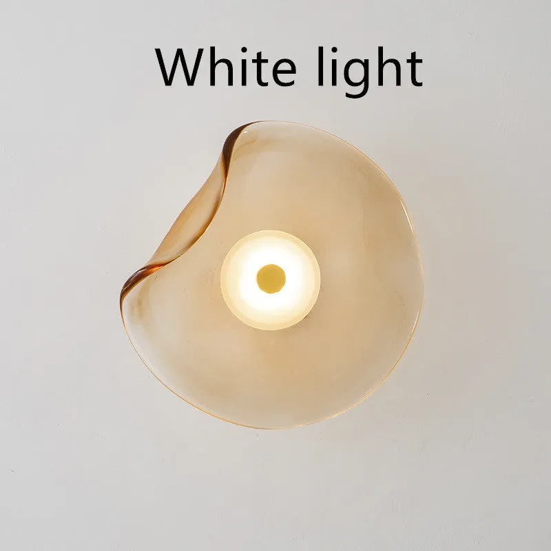 Round glass wall lamp for bedroom bedside in cognac, grey or light colour finishes.