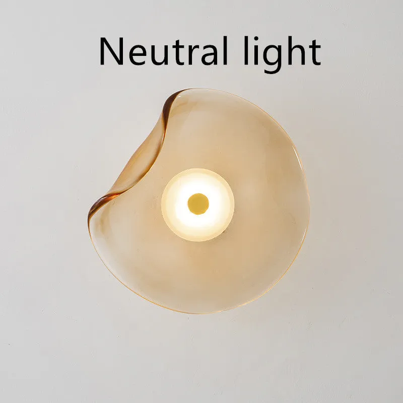 Round glass wall lamp for bedroom bedside in cognac, grey or light colour finishes.