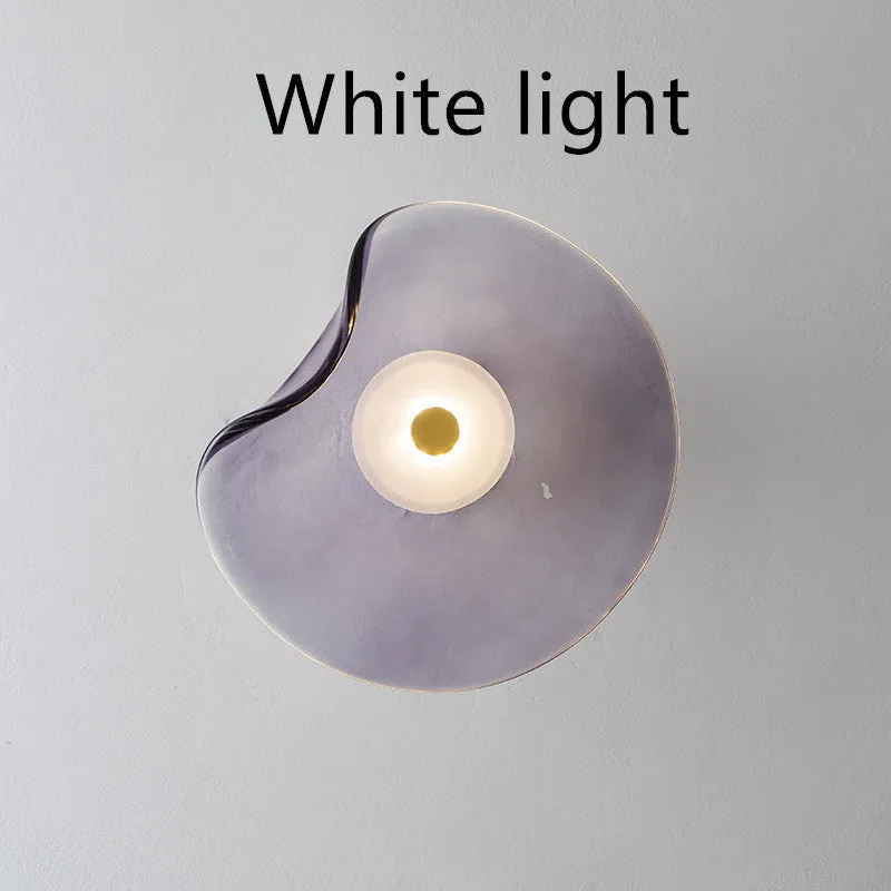 Round glass wall lamp for bedroom bedside in cognac, grey or light colour finishes.