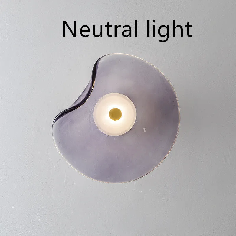 Round glass wall lamp for bedroom bedside in cognac, grey or light colour finishes.