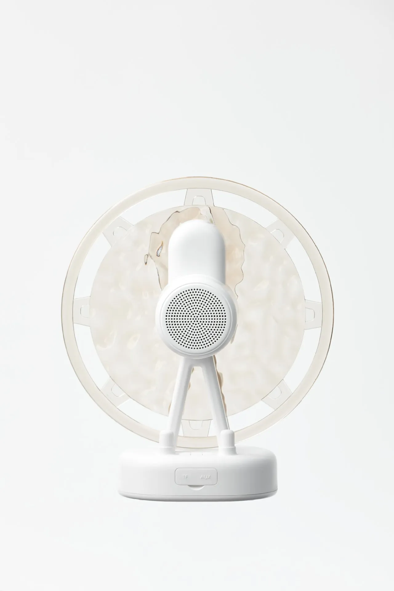 Pink Ferris wheel Bluetooth speaker projecting colourful water ripple light patterns on a surface.