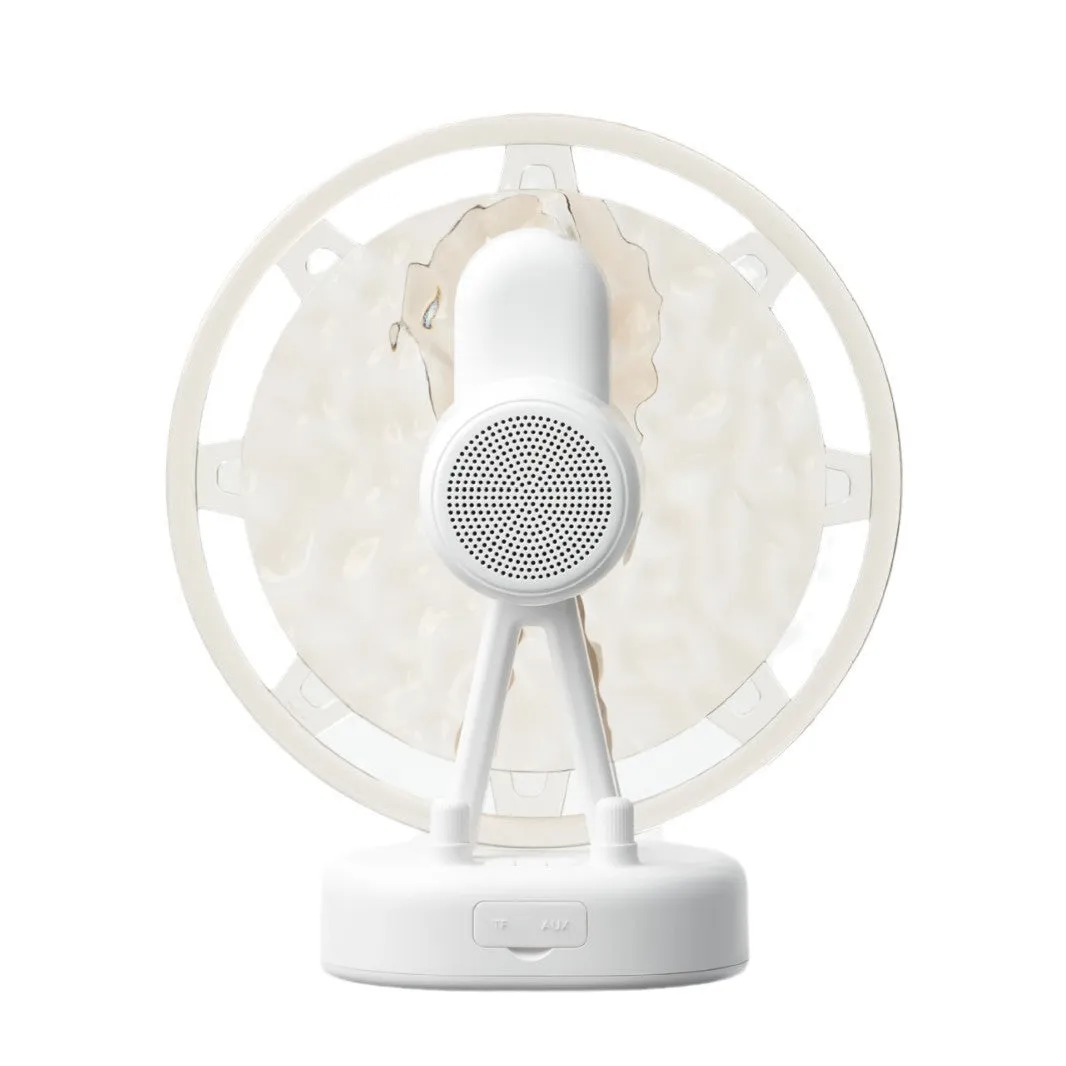 Pink Ferris wheel Bluetooth speaker projecting colourful water ripple light patterns on a surface.