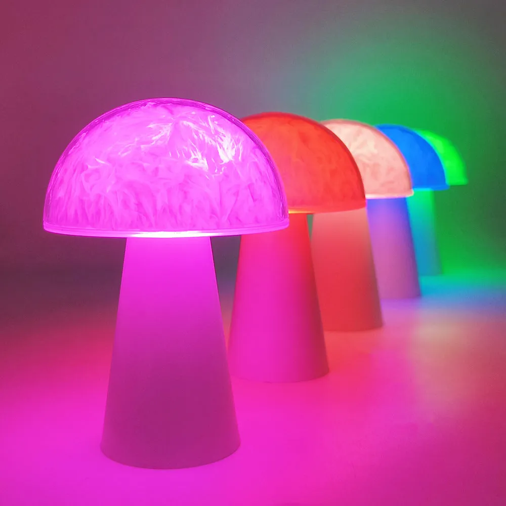 White mushroom-shaped night light with remote control on a wooden surface, showing soft RGB glow.