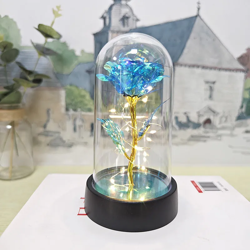 Small glass cover night lamp with plastic base and multiple LED colour options on a table.