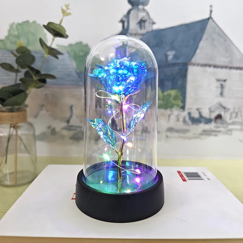 Small glass cover night lamp with plastic base and multiple LED colour options on a table.