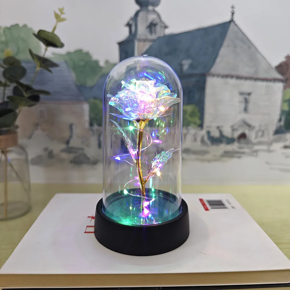 Small glass cover night lamp with plastic base and multiple LED colour options on a table.