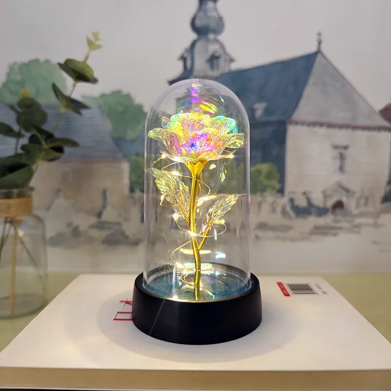Small glass cover night lamp with plastic base and multiple LED colour options on a table.