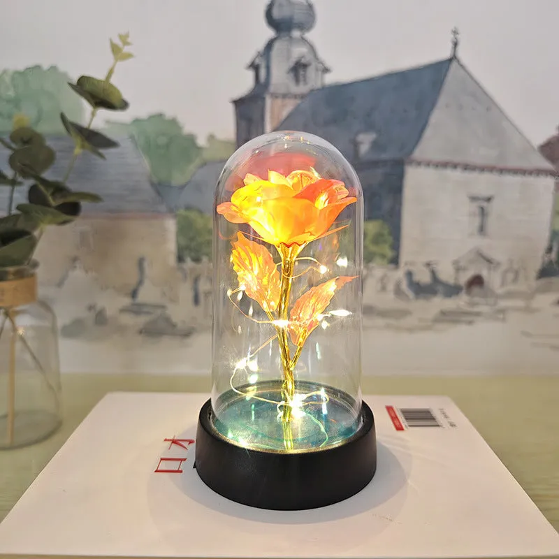 Small glass cover night lamp with plastic base and multiple LED colour options on a table.