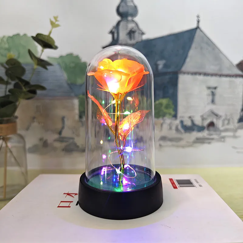 Small glass cover night lamp with plastic base and multiple LED colour options on a table.