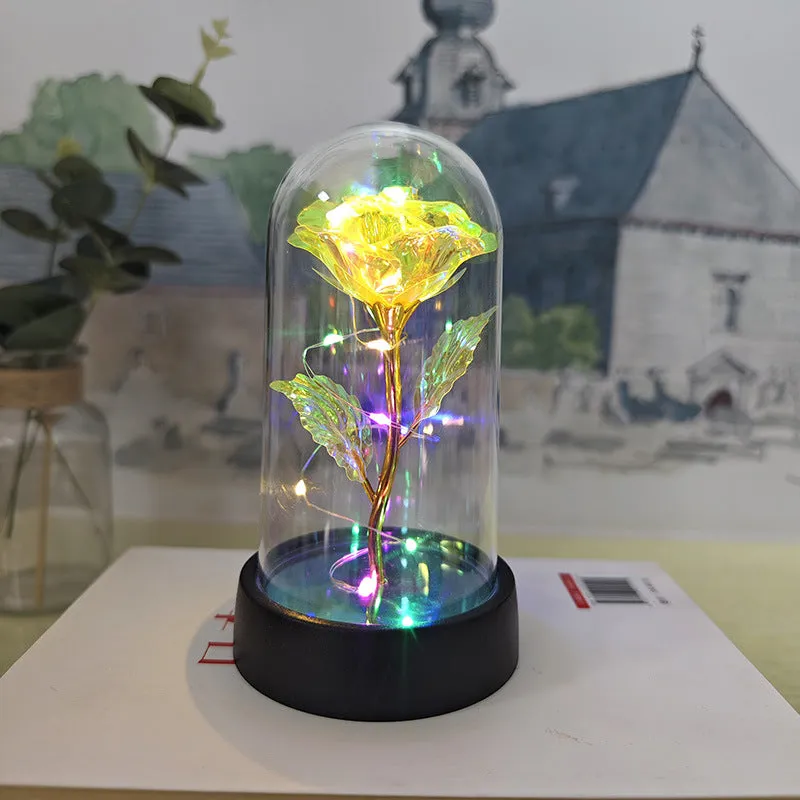 Small glass cover night lamp with plastic base and multiple LED colour options on a table.
