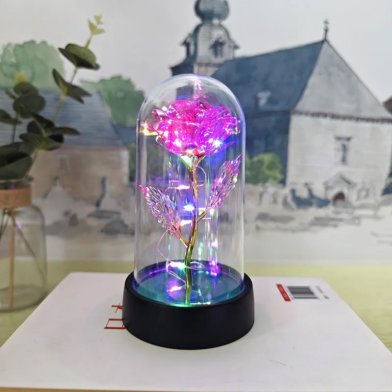 Small glass cover night lamp with plastic base and multiple LED colour options on a table.