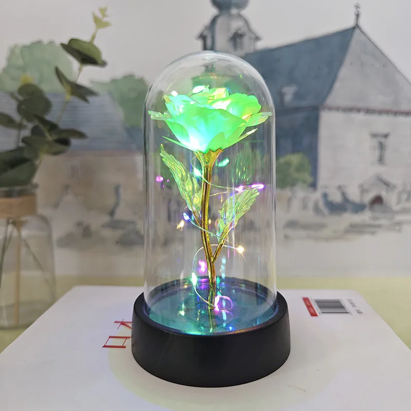 Small glass cover night lamp with plastic base and multiple LED colour options on a table.