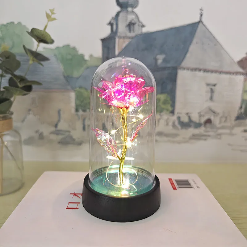 Small glass cover night lamp with plastic base and multiple LED colour options on a table.