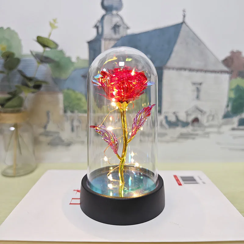 Small glass cover night lamp with plastic base and multiple LED colour options on a table.