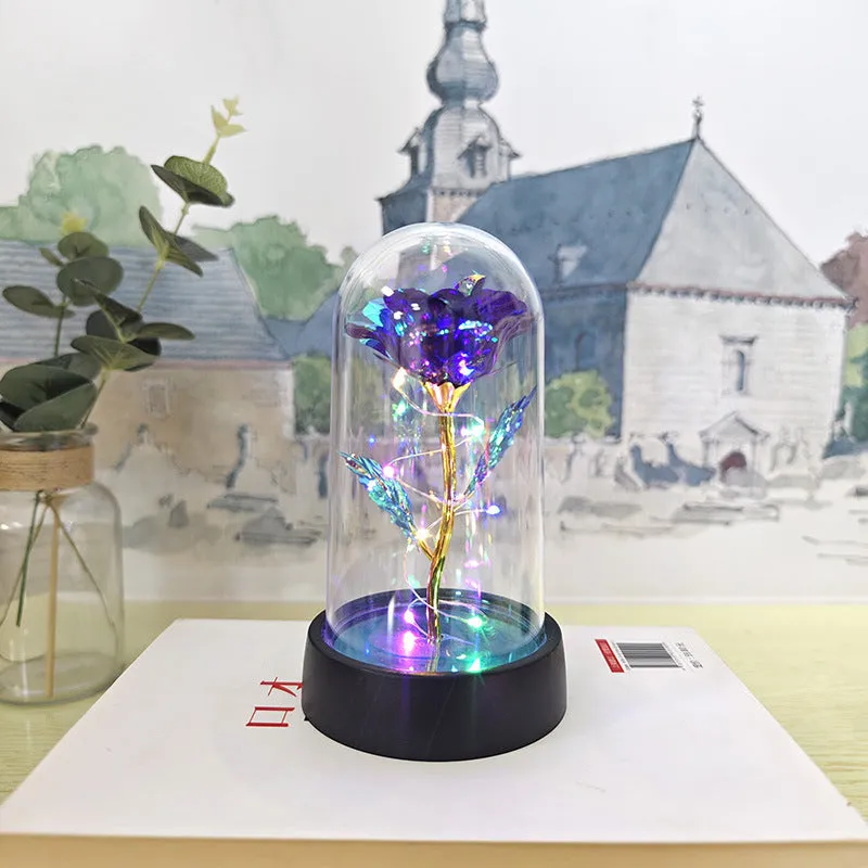 Small glass cover night lamp with plastic base and multiple LED colour options on a table.