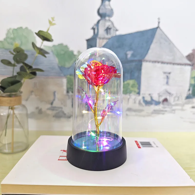 Small glass cover night lamp with plastic base and multiple LED colour options on a table.