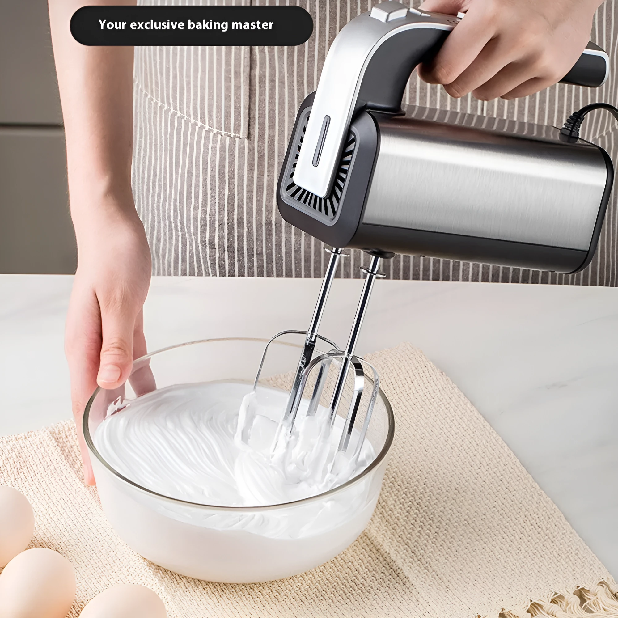 Silver handheld electric whisk with five speed settings and dual voltage compatibility