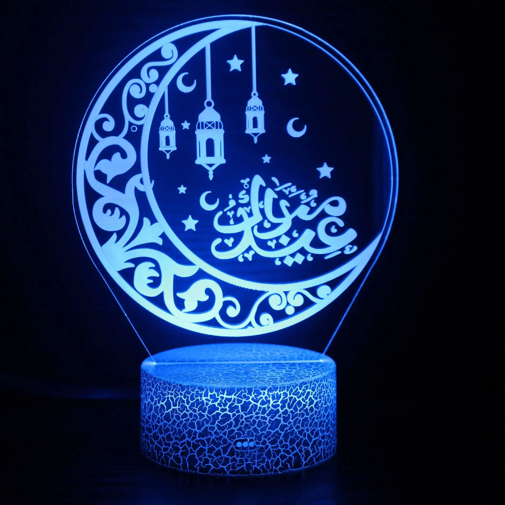 Cartoon-style 3D LED night light with black touch base and remote control on a bedside table.