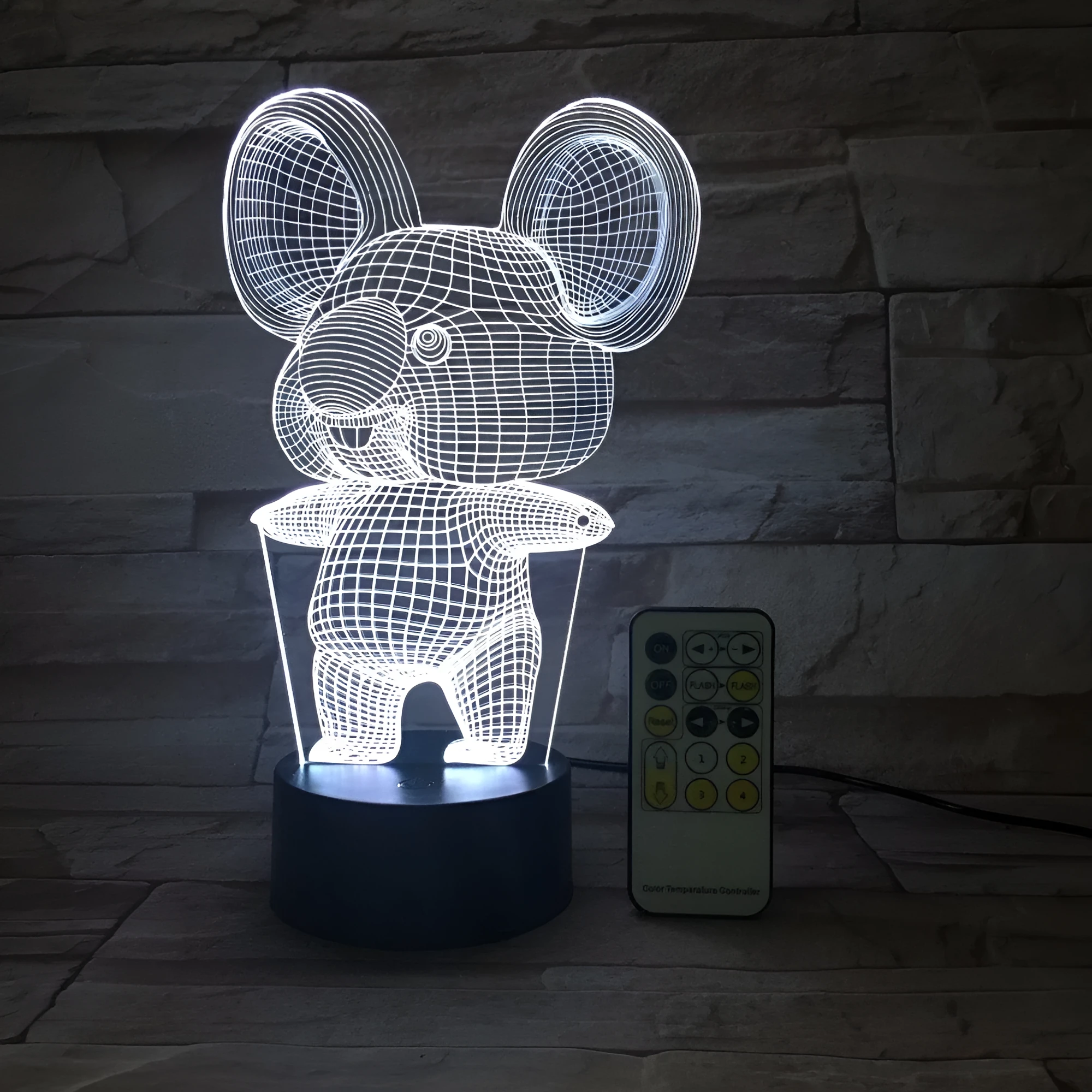 Koala-shaped night light with remote control showing seven colour options on a bedside table