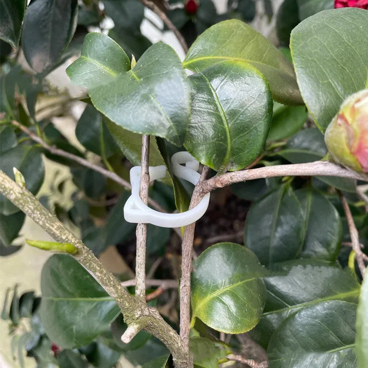 Small green plastic plant clip shaped like a cat, shown next to a plant stem.