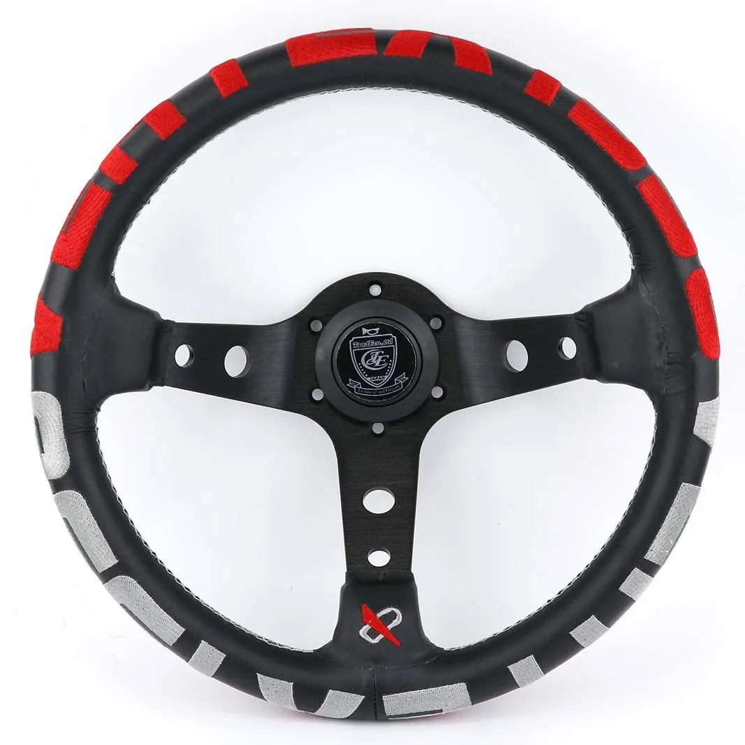 Black alloy racing steering wheel with deep concave rim and star embroidery pattern.