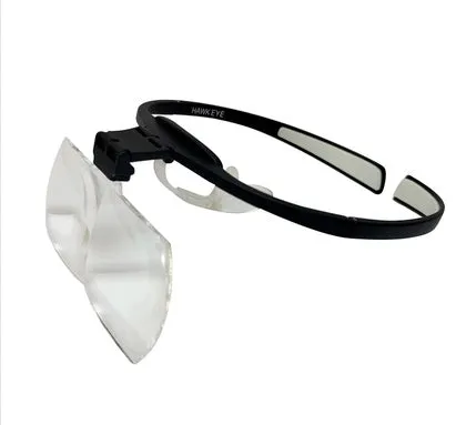 Head-mounted magnifying glass with large lenses on a black TR90 frame, shown with adjustable nose pad.