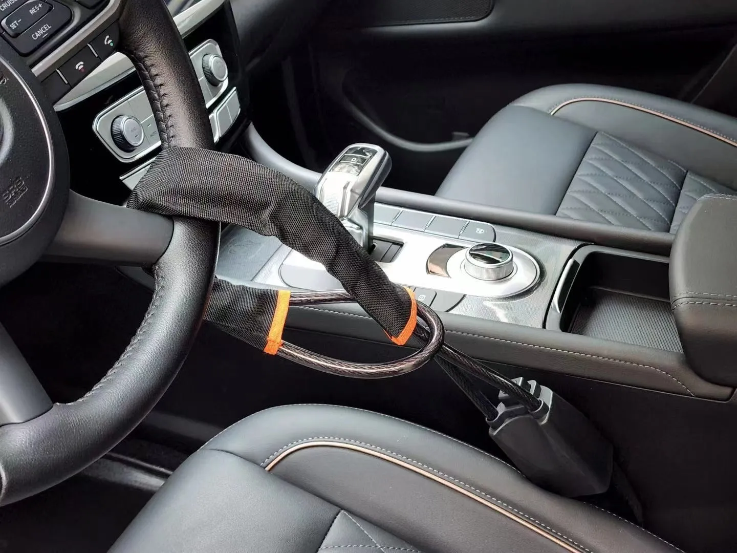 Red iron car steering wheel lock with copper core for General Motors vehicles on a steering wheel.