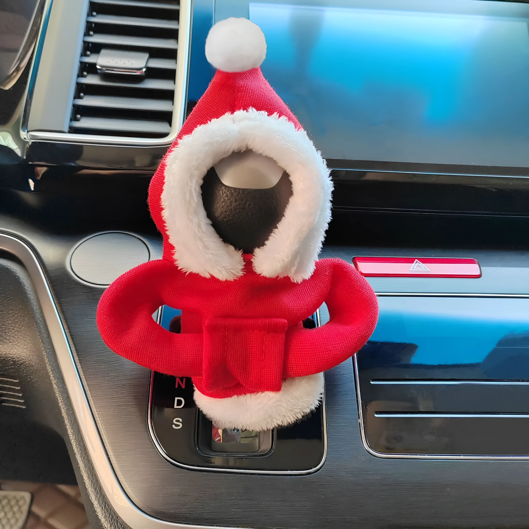 Red cloth hooded sweater cover on a car gear lever, showing decorative fur ball style.