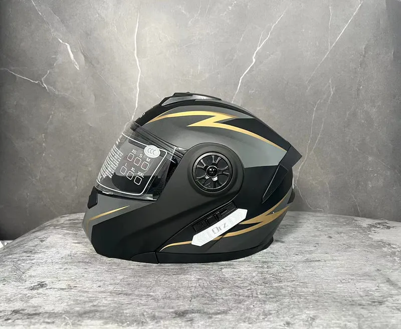 Matte black full face motorcycle helmet with integrated battery visor on a stand