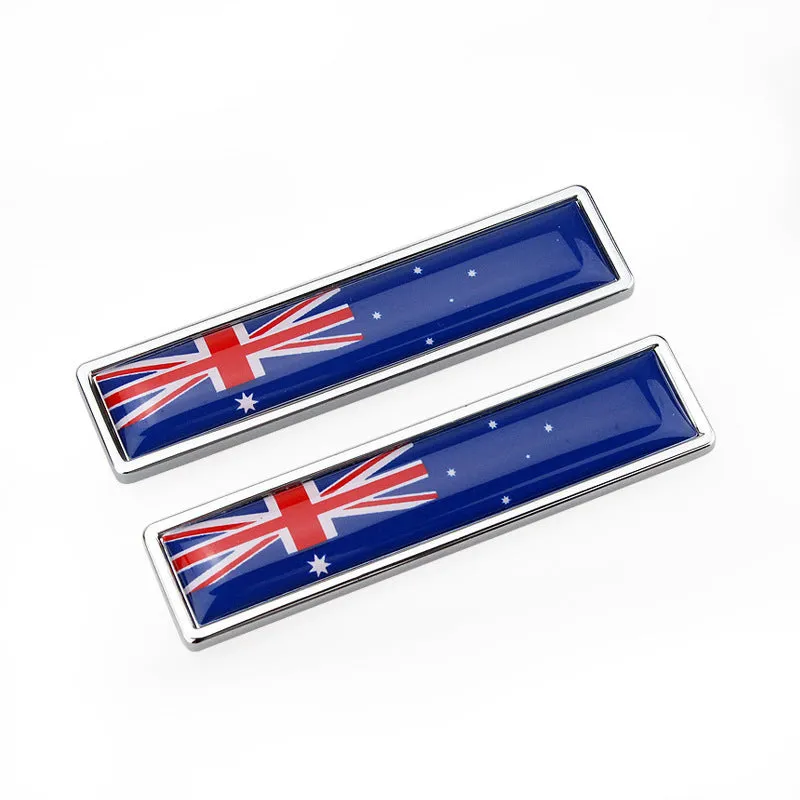 Pair of rectangular zinc alloy metal car badge stickers showing national flag designs, dimensions 58mm by 14mm.