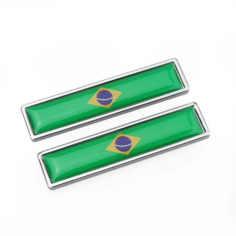 Pair of rectangular zinc alloy metal car badge stickers showing national flag designs, dimensions 58mm by 14mm.