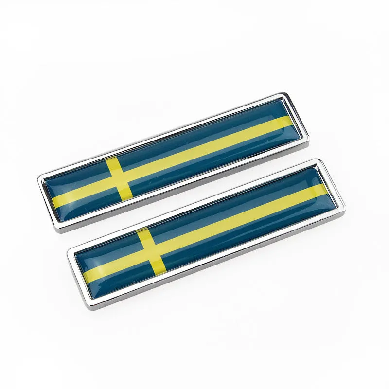 Pair of rectangular zinc alloy metal car badge stickers showing national flag designs, dimensions 58mm by 14mm.